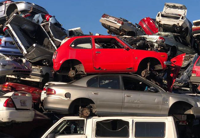 A jumble of vehicles, including damaged cars, illustrating the operations of Auto Wreckers in Brisbane.