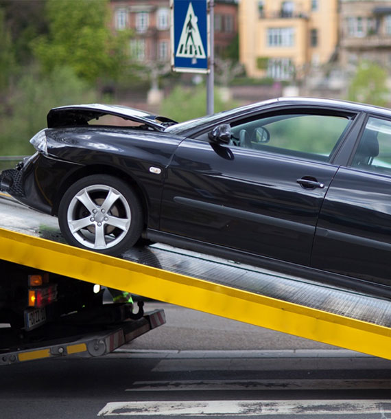 A flatbed truck with a black car, emphasizing car removal solutions in Brisbane.