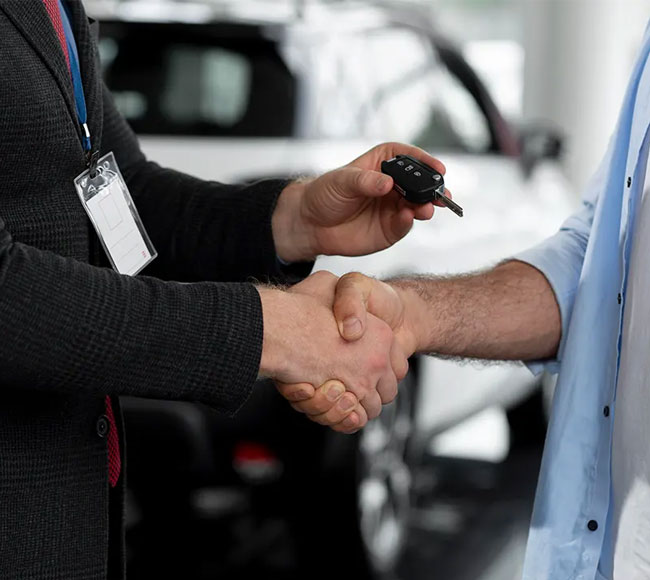 Two men shaking hands in front of a vehicle, illustrating a business agreement for Cash for Unregistered Cars in Brisbane.
