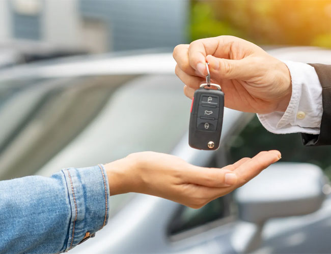 A man gives a car key to a woman, illustrating the Cash for Registered Cars initiative in Brisbane.